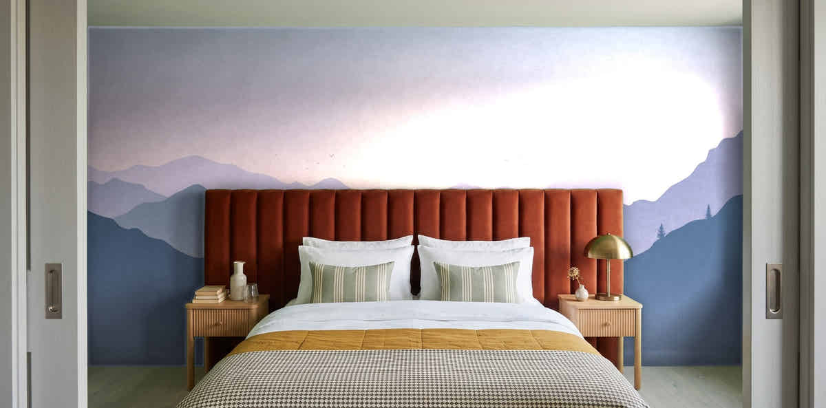 Papier peint Montagnes en strates – Lilas dans une chambre avec tête de lit terracotta