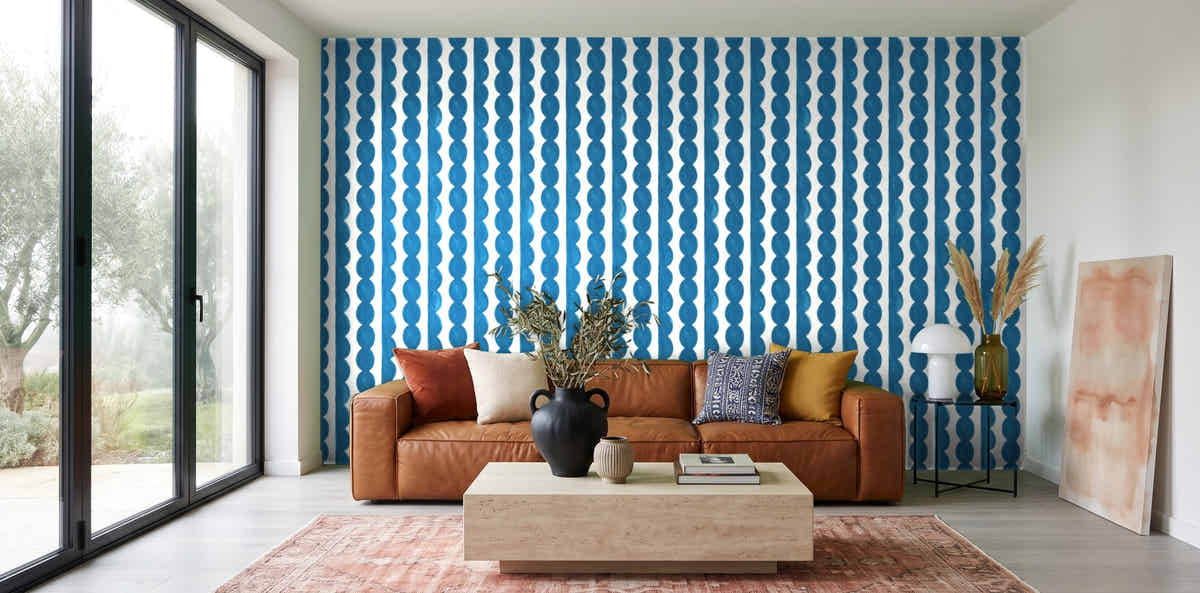 Papier peint Rayures festonnées – Bleu céruléen dans un salon avec baie vitrée